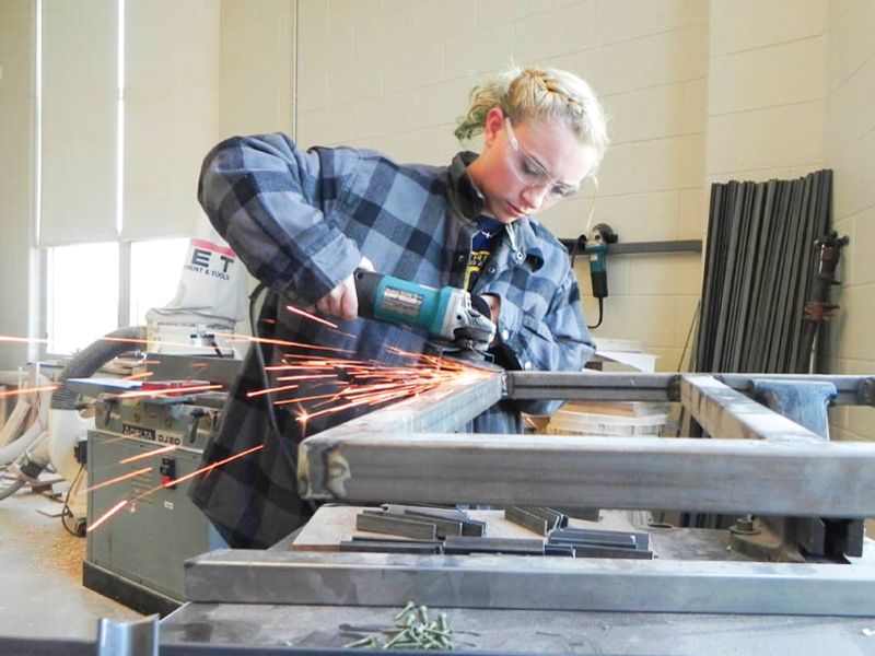 Student operating a metal grinder