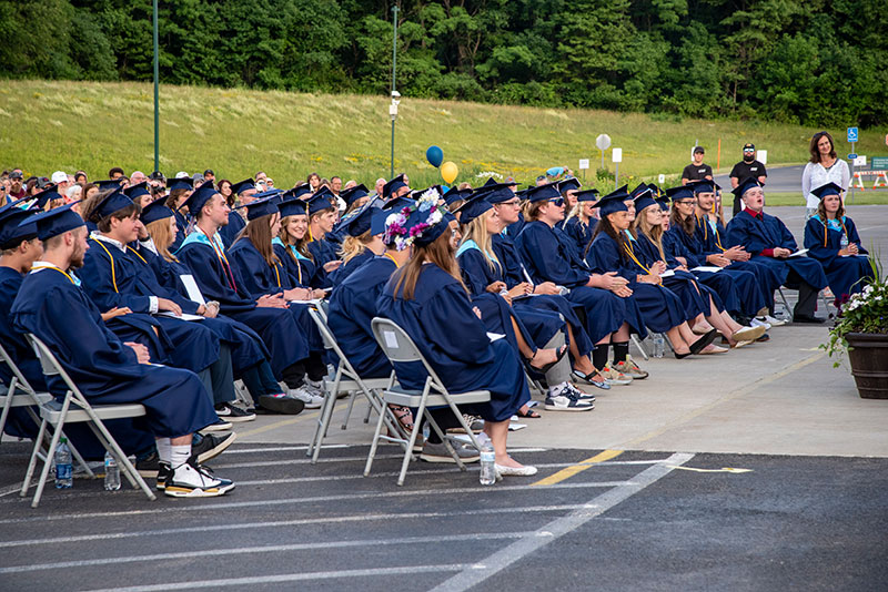 Students sitting in caps and gowns