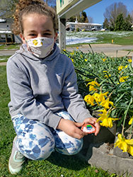 Student in the grass next to daffodils